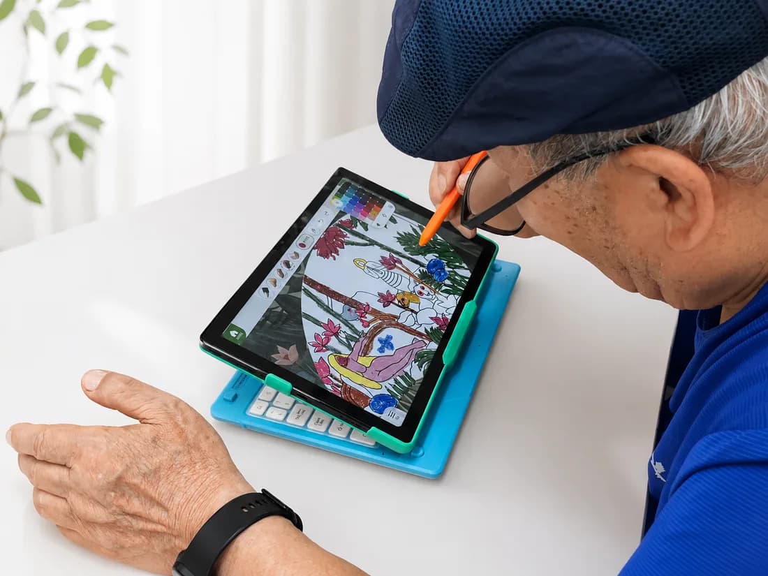 A senior looking closely at a digital artwork in progress